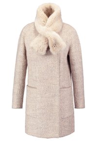 Cappotto in lana beige con un morbido colletto in finta pelliccia e dettaglio a fiocco. Presenta due tasche frontali e una vestibilità dritta con minime cuciture.