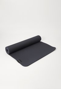 Yoga mat, dark grey, textured surface, rolled up partially, rectangular shape, with a small label on one edge.