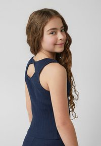 Top senza maniche color blu navy a coste con un'apertura a chiave sul retro e tessuto texturizzato, progettato per il comfort e un look aderente.