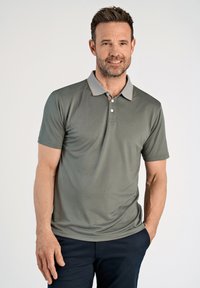 Lyhythihainen polo-paita oliivinvihreänä, jossa on teksturoitu kangas, vaaleanharmaa kaulus korostustikkauksilla ja kolmesta napista koostuva nappilista.