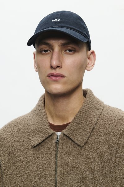 Jachetă din polar texturat maro, cu fermoar frontal și guler, asociată cu o șapcă de baseball bleumarin, cu inscripția albă "W.W."