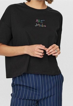 Sort bomulds t-shirt med en løs pasform, der har flerfarvet broderet tekst "ART studio" på brystet. Kombineret med stribede bukser.
