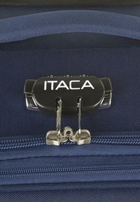 Maleta azul marino con cierre de cremallera negro con el logo "ITACA", herrajes metálicos y superficie de tela texturizada.
