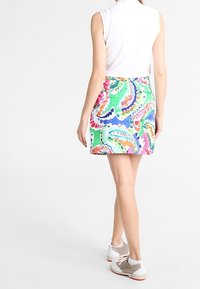 Pestrobarevná sukně s motivem paisley, vyrobená z lehkého materiálu, s přiléhavým pasem a mírně rozšířeným lemem.