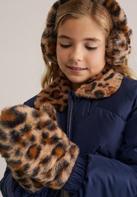 Mornarska podložena jakna z rjavim ovratnikom iz umetnega krzna z leopardjim vzorcem, usklajene ušesne zaščite iz krzna in rokavicami, ki vsebujejo podobne vzorce in teksture.