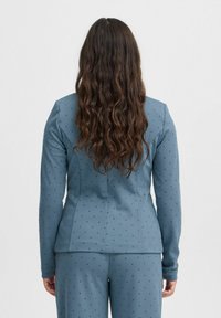 Blå kavaj med prickar, lång ärm, skräddarsydd passform, texturerad tyg och subtil lyster, parat med matchande byxor.
