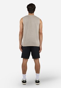 Grå ærmeløs top i ribbet tekstur, parret med sorte shorts. Viser et enkelt, funktionelt design.