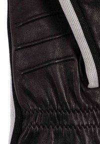 Guanto in pelle nera con superficie testurizzata, caratterizzato da più cuciture verticali e un polsino arricciato. Accentato con un elastico bianco a contrasto.