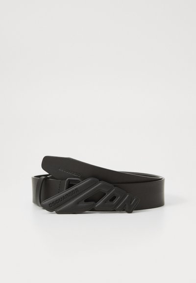 Ceinture en caoutchouc noir avec une boucle moulée en forme de CB. Présente le nom de la marque embossé, une texture lisse et un design épuré.