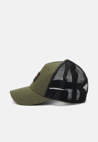Casquette olive avec un dos en maille noire, visière incurvée et un patch en tissu sur le devant. L'arrière dispose d'une fermeture à pression pour un ajustement.