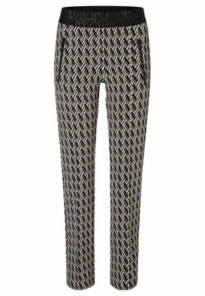 Pantalon à motifs noirs et blancs avec un design en chevrons, taille élastique et poches latérales zippées. Coupe slim avec une jambe fuselée.