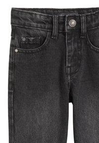 Jeans en denim noir avec poches avant, passants de ceinture et fermeture à bouton métallique.