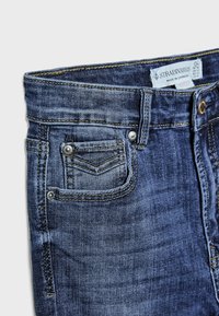 Donkerblauwe denim jeans met een klassiek vijf-pocket ontwerp, met stikdetails, een knoop aan de voorkant en een label op de tailleband.