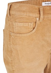 Benvitade byxor i ljusbeige med texturerade åsar, en enda framficka och standard sömmar. Elastisk midja.