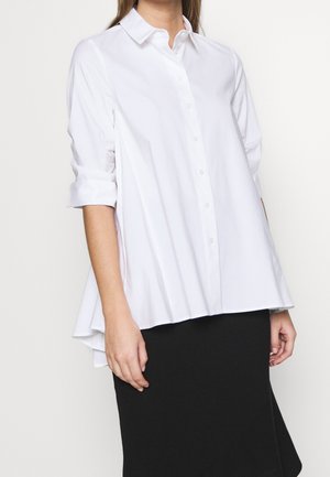 Witte overhemd met kraag en knopen, opgerolde mouwen, ontspannen pasvorm en afgeronde zoom. Gladde, lichtgewicht stof zonder zichtbare patronen.