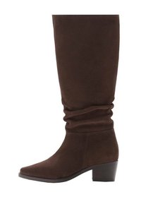 Bruine suède kniehoge laars met een slouchy ontwerp, vierkante neus en een blokhak. Soepele textuur en minimale zichtbare stiksels.