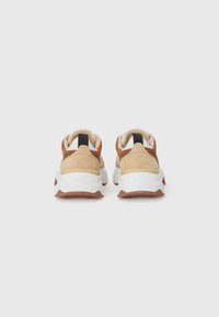 Beige og brune sneakers med en teksturert semsket skinn og glatt skinn overdeler, hvit mellomsåle og en brun yttersåle; svart helpull-tab.