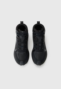 Zapatillas deportivas negras con un upper texturizado, acentos de patrón hexagonal y una puntera reforzada. Presentan cierre con cordones y soporte para el tobillo.