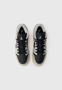 Basketballsneakers med svart lädertå och mittsektion, grå mockaöverdel, svarta snören och beige gummisula. Har en ikonisk logotyp på tungan.