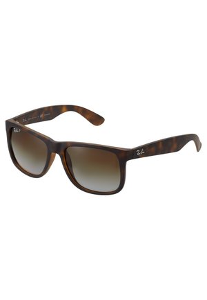 Gafas de sol de carey con lentes rectangulares, tinte marrón degradado, montura gruesa y un logo en la patilla izquierda. Material plástico duradero.