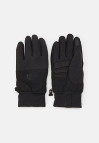 Gants noirs avec tricot texturé et extérieur lisse, présentant un logo, des accents de prise sur la paume et des poignets élastiques pour un ajustement sécurisé.