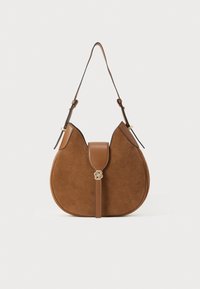 Sac à bandoulière en daim marron avec un design courbé, doté d'une sangle en cuir et d'un accent logo doré sur le rabat avant. Texture lisse.