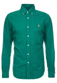 Camisa verde de manga larga con botones, hecha de algodón, con un cuello clásico, botones blancos y un pequeño logo amarillo en el pecho izquierdo.