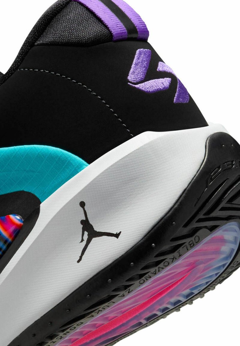 Zwarte sneaker met paarse accenten, turquoise details en een witte zool. Heeft een gestructureerde bovenkant en een zwarte Jumpman-logo aan de zijkant.