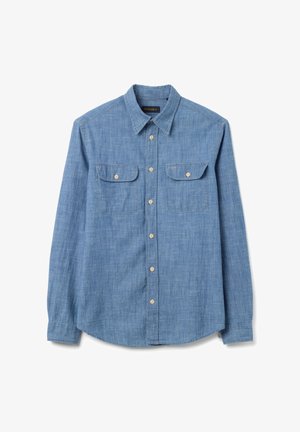 Camisa de manga larga color azul claro en tela chambray con cuello abotonado, dos bolsillos en el pecho y un dobladillo curvado. Los botones son de color beige claro.