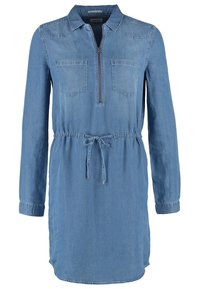 Džínové šaty s dlouhými rukávy, límcem a předním zipem. Mají dvě náprsní kapsy a stahovací pas pro úpravu. Světle modrá barva.
