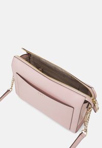 Różowa syntetyczna torebka z fakturowaną powierzchnią, złotym zamkiem błyskawicznym, zewnętrzną kieszenią i łańcuszkowym paskiem. Wnętrze z przegródką do organizacji.