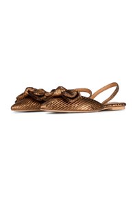 Sandali in bronzo con dettaglio annodato, caratterizzati da una texture rigata e suola piatta. Le cinghie regolabili sono minimali, esaltando il design elegante.
