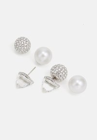 Conjunto de pendientes que incluye dos perlas, un diseño de bola de cristal y un acento geométrico claro, todo en metal de tono plateado.