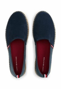 Scarpe slip-on blu navy in materiale scamosciato, con fodera interna rossa, suola in juta intrecciata e cuciture a contrasto lungo i bordi.