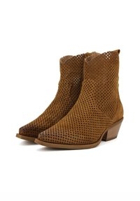 Stivaletti alla caviglia in suede marrone con design perforato, punta affusolata e tacco impilato. Presentano una superficie testurizzata e un motivo aperto per la ventilazione.