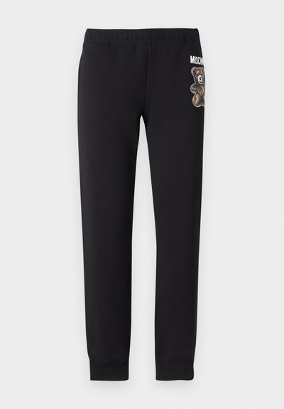 Melni sporta bikses, izgatavotas no mīkstas auduma, ar lāča grafiku un tekstu uz kreisā augšstilba. Elastīgs jostasvietas un sašaurināti piedurkņu gali.