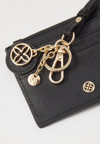 Black textured wallet with gold hardware. Features a chain, keyring clip, and logo accents on the exterior. Compact and functional design.