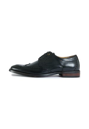 Black leather men's brogue shoe with wingtip design, lace-up closure, and wooden heel detail on white background.
