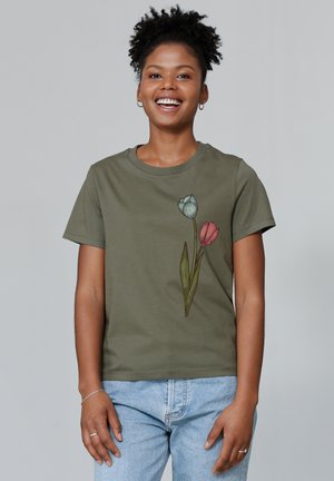 Olivgrünes Baumwoll-T-Shirt mit einem botanischen Design von blauen und rosa Tulpen sowie grünen Blättern auf der linken Seite. Kurze Ärmel, runder Halsausschnitt.