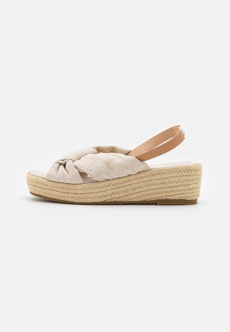 Sandale compensée en tissu beige avec des brides avant torsadées, une bride arrière en cuir marron clair et une semelle plateforme en jute tressé.