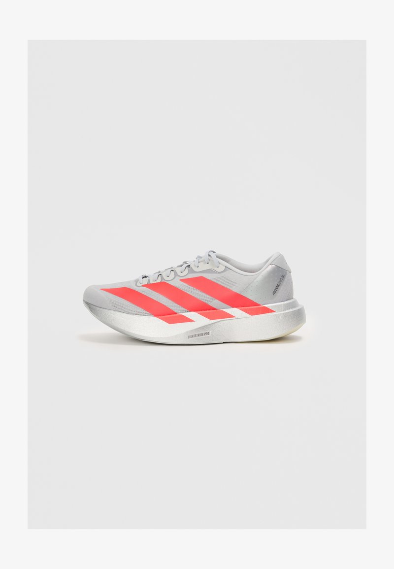 Lightweight running shoe in gray with red accents and three stripe design. Features a smooth upper, rounded toe, and textured sole.