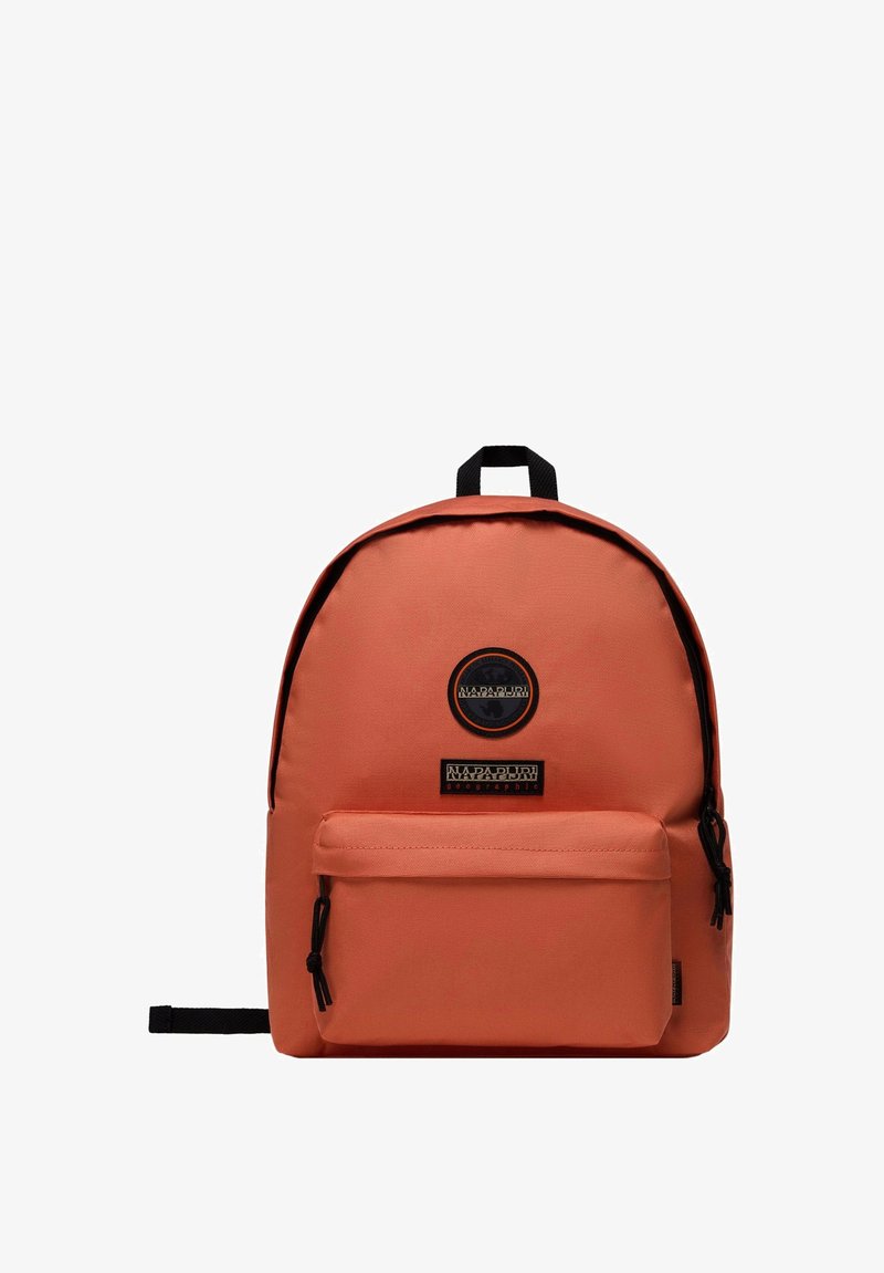 Zaino in tessuto arancione con design arrotondato, tasca frontale con zip e patch logo nero. Comprende spallacci regolabili e una maniglia superiore.