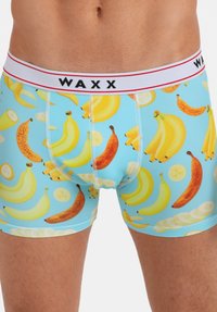 Boxers pour hommes avec un fond bleu clair, ornés d'un motif de bananes de différentes tailles. Taille élastique avec texte de logo.