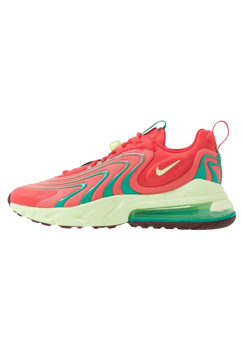 Röda och gröna Nike Air Max-sneakers med vågiga gröna accenter, krämfärgad sula, transparent luftkudd och gul Nike-swoosh på sidan.