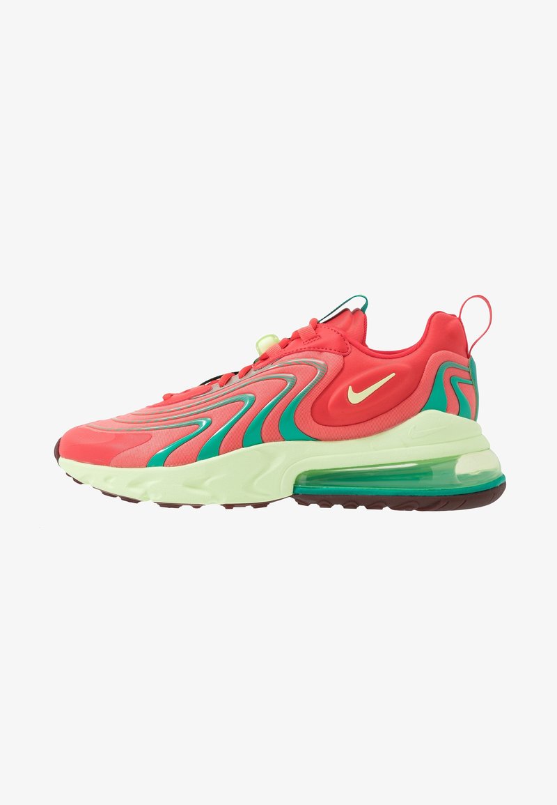 Red and green Nike Air Max sneaker with wavy green accents, cream sole, transparent air cushion, and yellow Nike swoosh on the side.