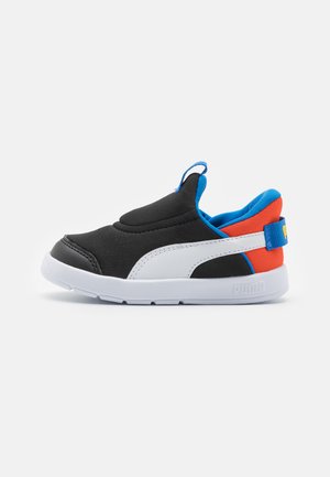 Chaussure noire à enfiler avec semelle blanche, accents bleu et rouge, tige en tissu lisse et une languette à l'arrière pour un enfilage facile.