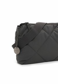 Quilted black nylon crossbody bag with a smooth texture, featuring a wide fabric strap, chain detailing, and a metal tag with "Emily & Noah."