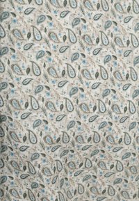 Lichtbeige stof met een herhalend paisleypatroon in blauw en groen, met kleine florale accenten en een gestructureerde uitstraling.