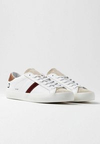 Hvide sneakers med en glat læderoverdel, beige ruskinds tå og maroon stribe. Har en flad sål, rund snørebånd og branding på siden.