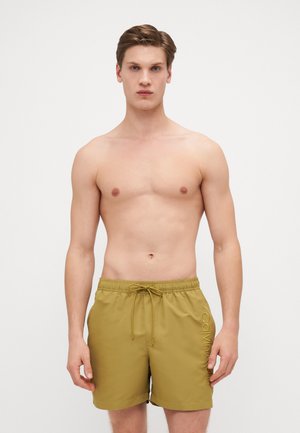 Maslinasto zelene kupaćice s elastičnom trakom, podesivim vezanjem i bočnim džepovima. Sadrži "Calvin Klein" logo u kontrastnoj boji sa strane.